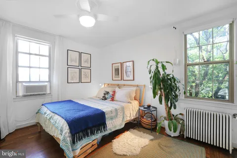 a bedroom with a bed and a large window