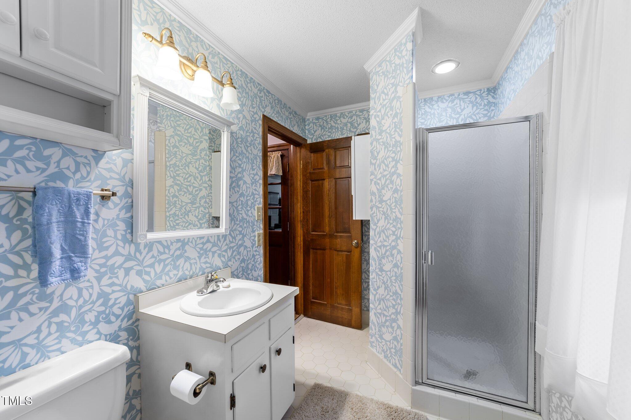 5012 Springwood Drive Raleigh, NC 27613 - Photo 21 of 44 a bathroom with a sink a toilet and shower