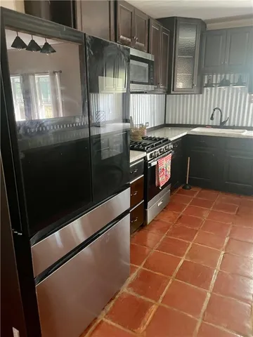 a kitchen with granite countertop a refrigerator and a stove