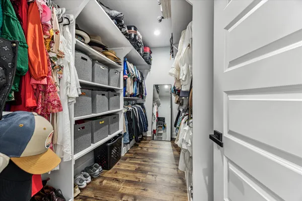 a view of walk in closet with clothes and shoes