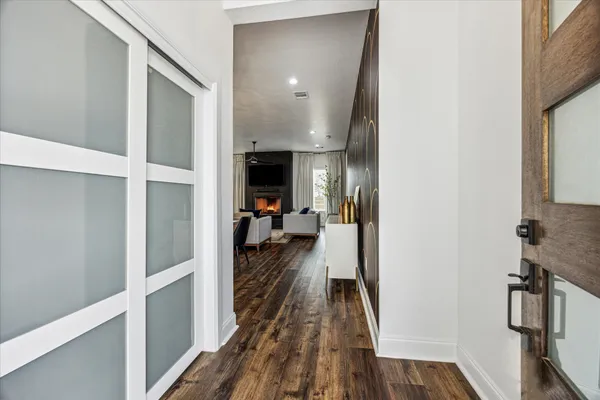 a view of a hallway view with living room and wooden floor