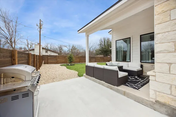 a view of a patio with couches chairs and wooden fence