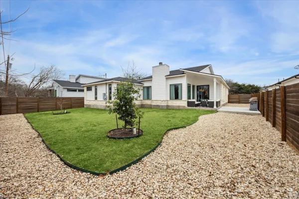 a front view of a house with a yard and trees