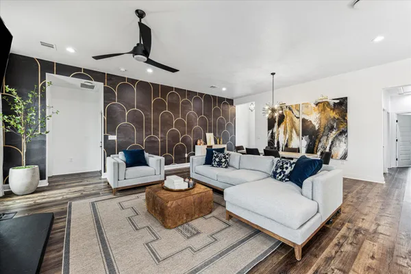 a living room with furniture ceiling fan and a rug