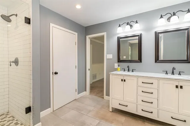 a spacious bathroom with a double vanity sink and a mirror