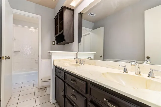 a bathroom with a granite countertop sink a toilet and a large mirror