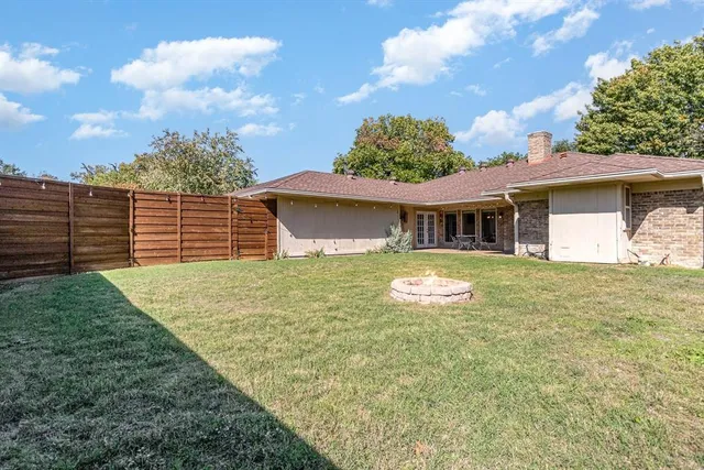 a view of an house with backyard space and balcony