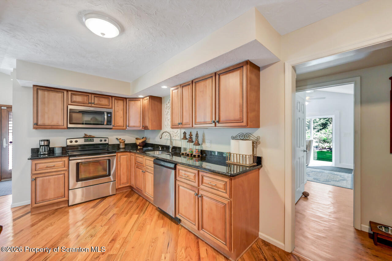 3660 Aberdeen Road Moscow, PA 18444 - Photo 21 of 68 a kitchen with granite countertop wooden floors and stainless steel appliances