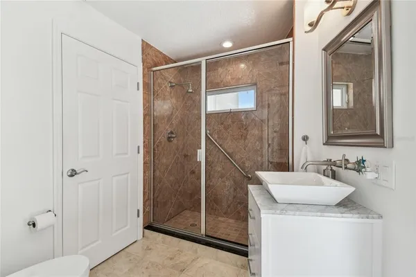a bathroom with a granite countertop sink and a window