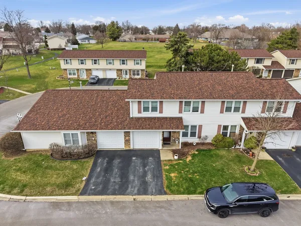 an aerial view of a house with a garden and lake view