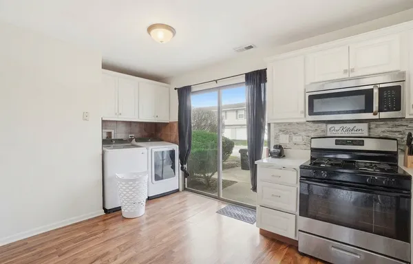 a kitchen with a refrigerator stove and white cabinets