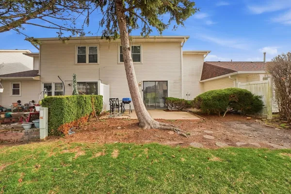 a view of a house with backyard and a tree