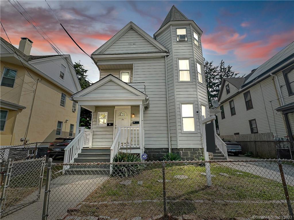 74 Carleton Avenue Bridgeport, CT 06604 - Photo 1 of 1 a front view of a house with garden