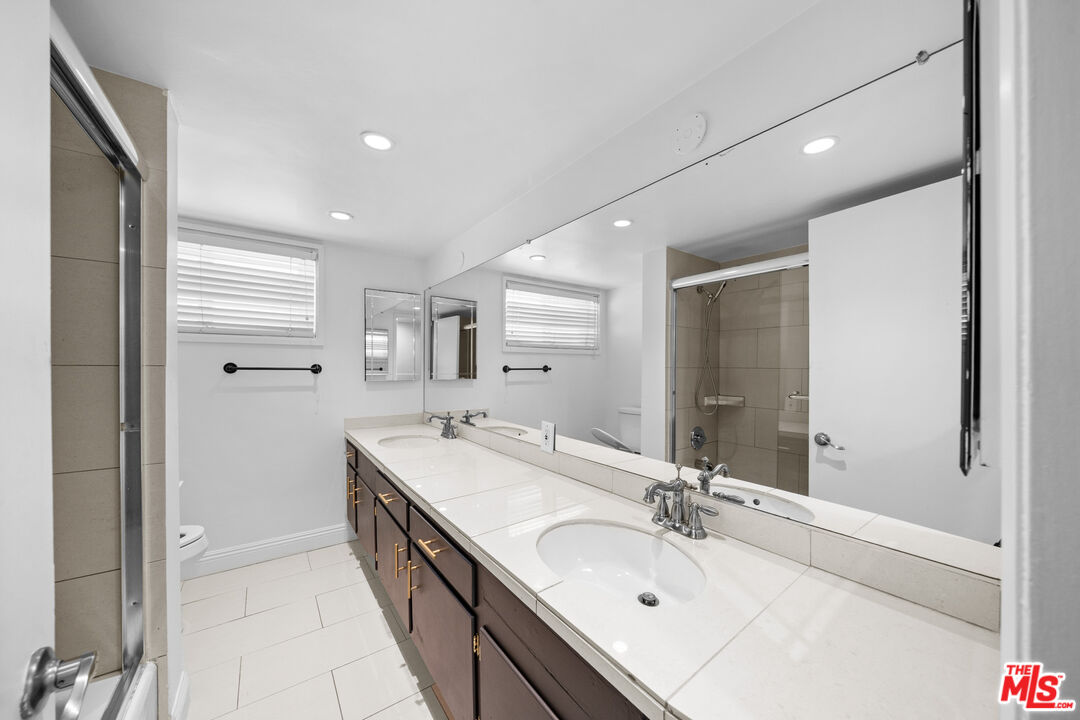 148 South Reeves Drive, Unit 4 Beverly Hills, CA 90212 - Photo 11 of 27 a bathroom with a double vanity sink a mirror and a shower