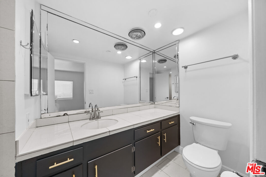 148 South Reeves Drive, Unit 4 Beverly Hills, CA 90212 - Photo 20 of 27 a bathroom with a double vanity sink toilet mirror and shower