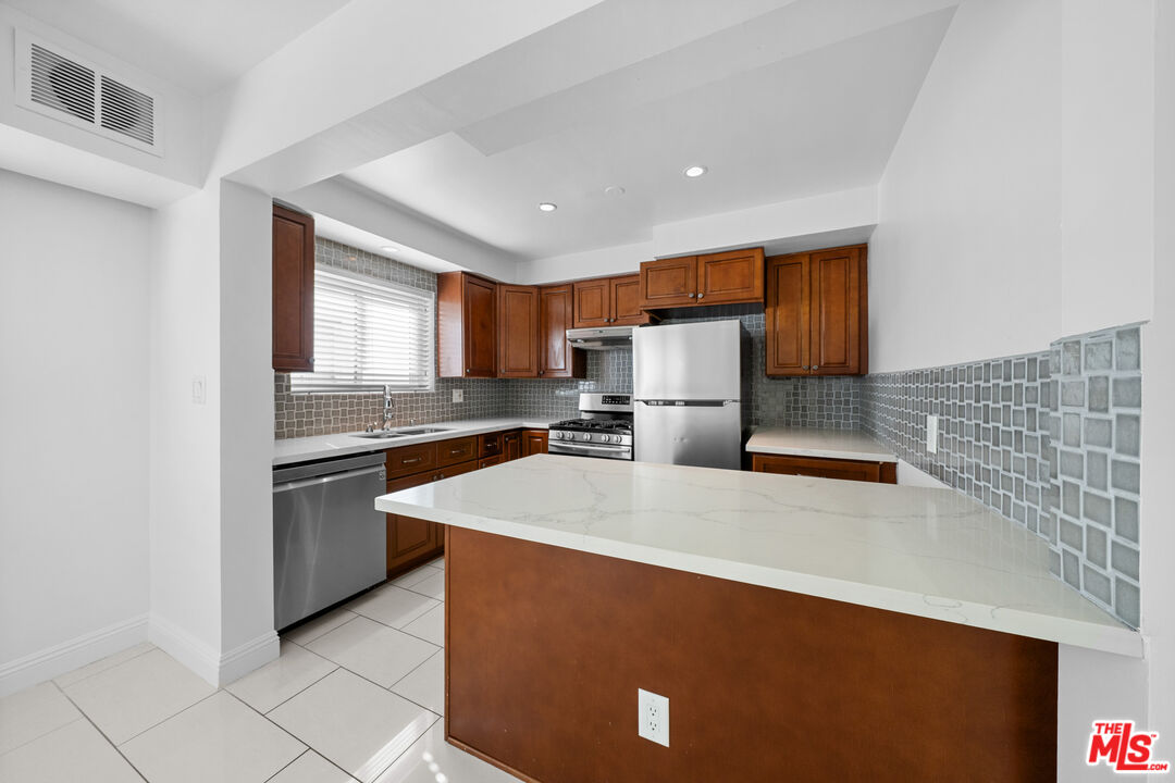148 South Reeves Drive, Unit 4 Beverly Hills, CA 90212 - Photo 5 of 27 a kitchen with stainless steel appliances a refrigerator sink and cabinets