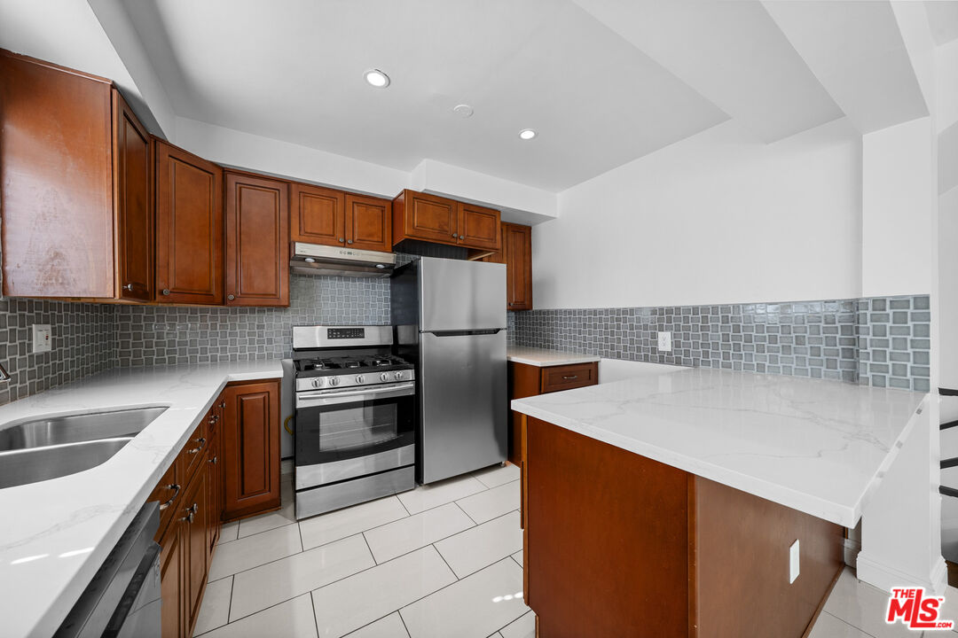 148 South Reeves Drive, Unit 4 Beverly Hills, CA 90212 - Photo 6 of 27 a kitchen with stainless steel appliances granite countertop a sink stove and refrigerator