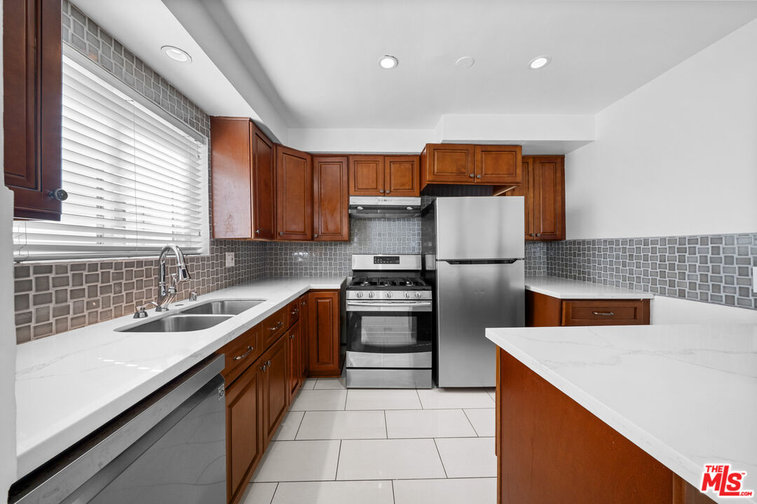 148 South Reeves Drive, Unit 4 Beverly Hills, CA 90212 - Photo 7 of 27 a kitchen with stainless steel appliances granite countertop a sink stove and refrigerator