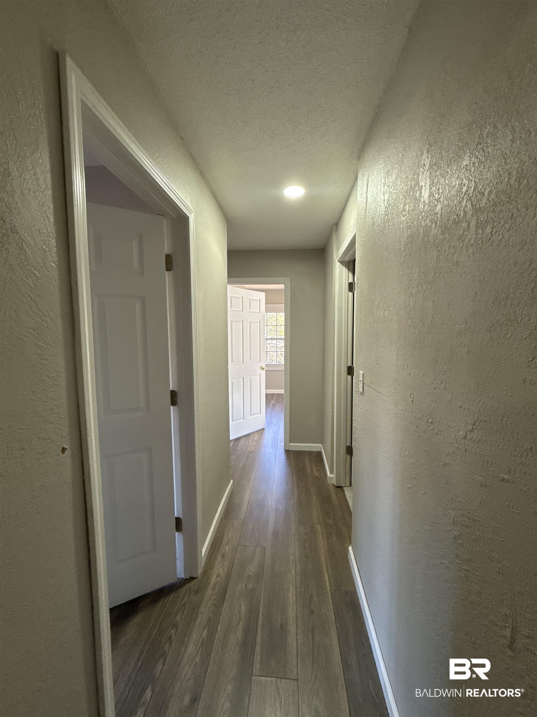 32 Slate Street Atmore, AL 36502 - Photo 8 of 16 Corridor featuring a textured wall, a textured ceiling, and dark wood finished floors