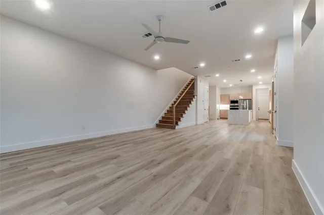 a view of a hallway with wooden floor and a ceiling fan