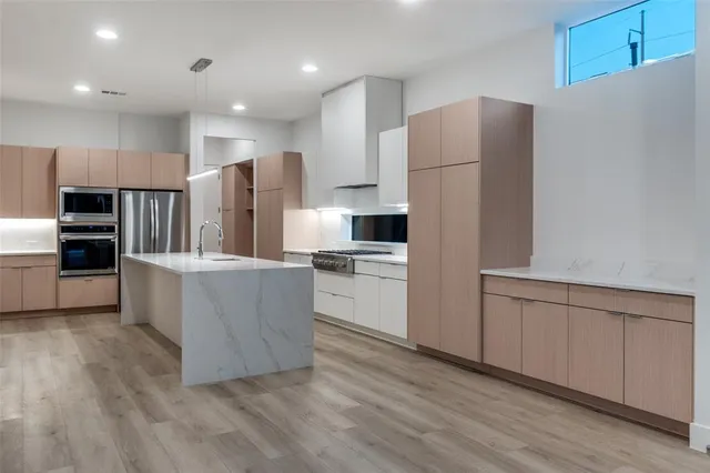a kitchen with kitchen island white cabinets and stainless steel appliances