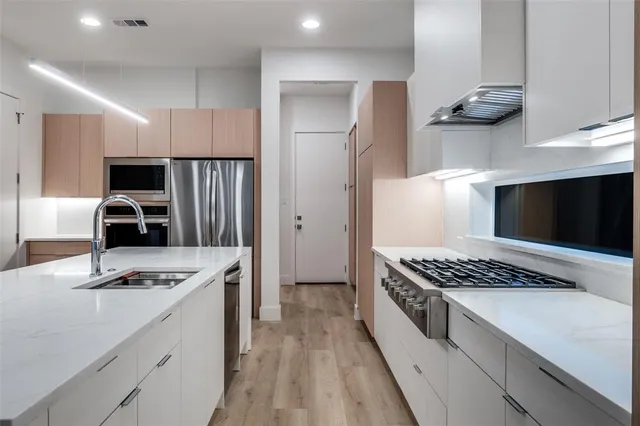 a kitchen with a refrigerator and a stove top oven