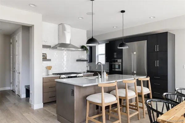 a kitchen with stainless steel appliances granite countertop a stove a sink and a refrigerator