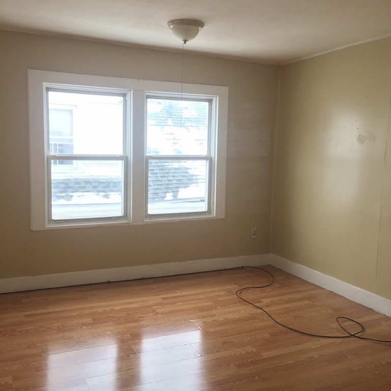 56 Windsor Street Springfield, MA 01105 - Photo 11 of 14 a view of an empty room with wooden floor and a window