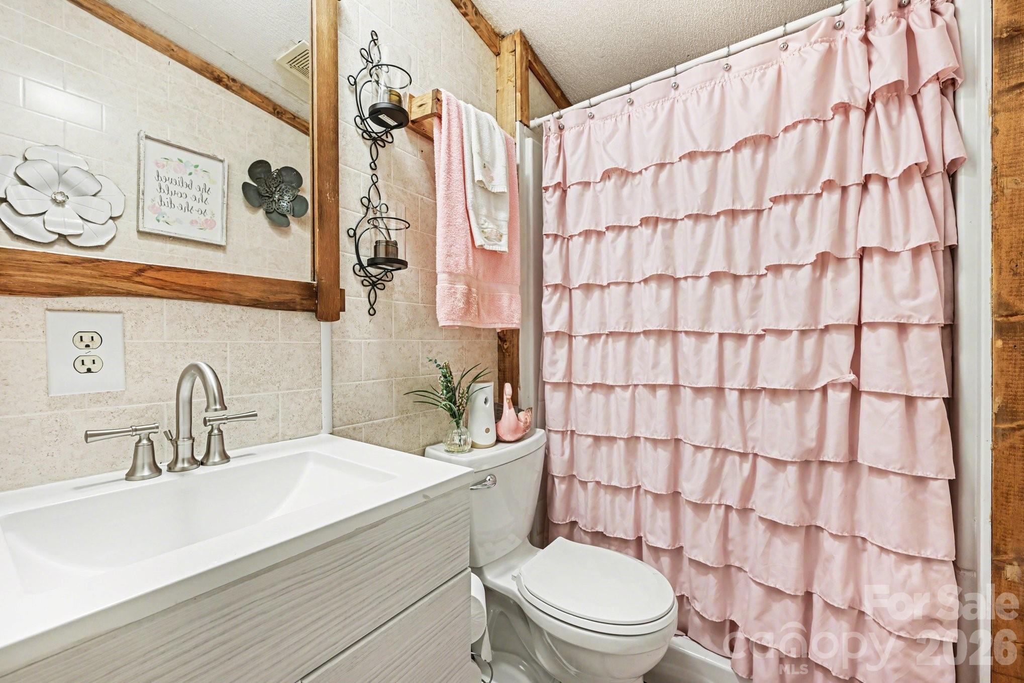 5431 Polkville Road Casar, NC 28020 - Photo 13 of 24 a bathroom with a sink a toilet and shower curtain