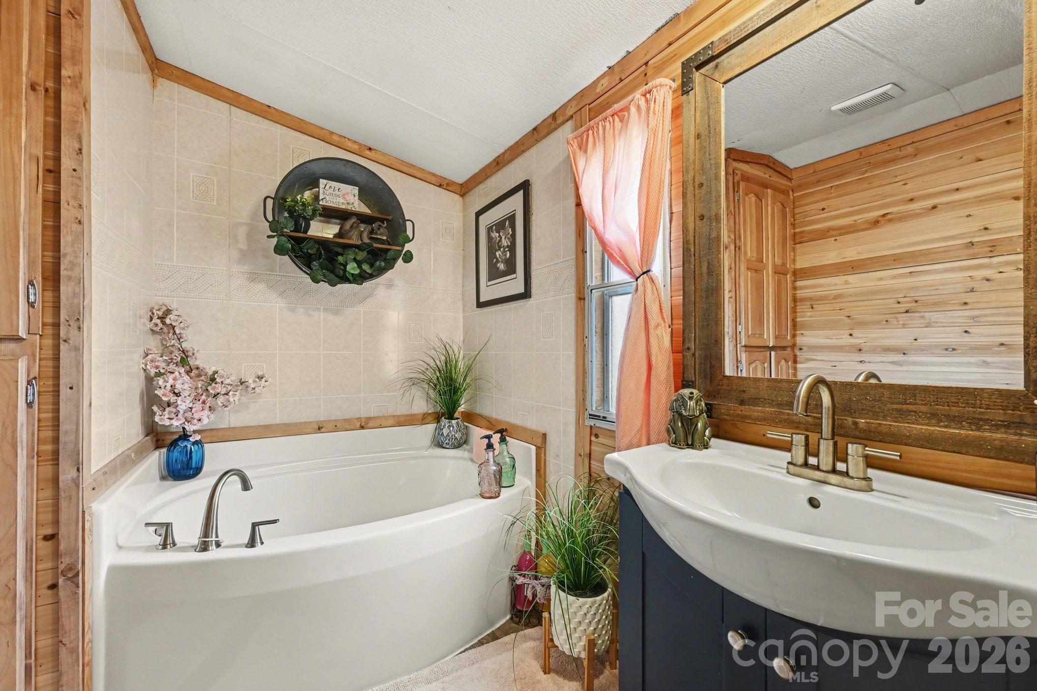 5431 Polkville Road Casar, NC 28020 - Photo 17 of 24 a bath tub sitting next to a white sink and a mirror