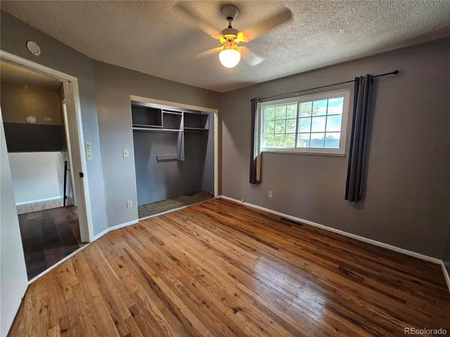 a bedroom with a bed and a chandelier fan
