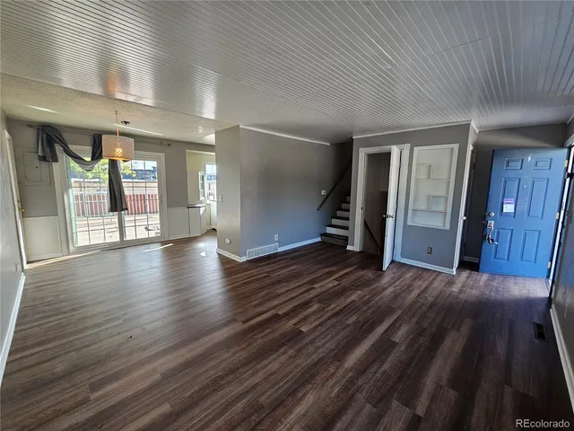 a view of a hallway with wooden floor and stairs