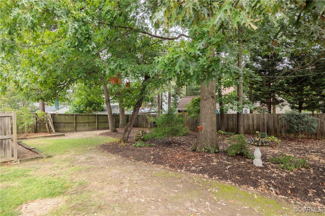 3510 Wood Dale Road Chester, VA 23831 - Photo 41 of 50 a backyard of a house with lots of plants and large tree