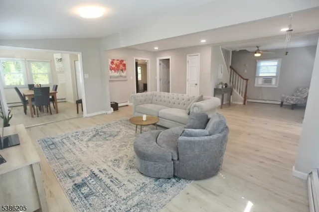 a living room with furniture and a dining table with kitchen view