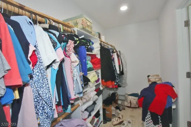 a view of walk in closet with clothes and shoes