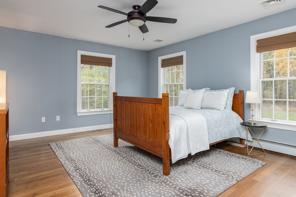 326 Old Ayer Road Groton, MA 01450 - Photo 28 of 42 a bedroom with a bed rug and wooden floor