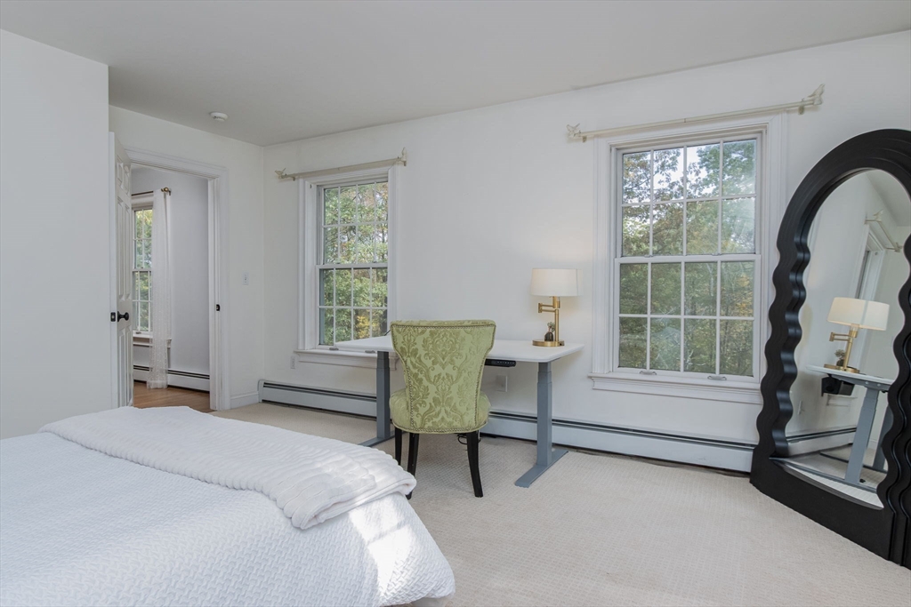 326 Old Ayer Road Groton, MA 01450 - Photo 30 of 42 a bedroom with a bed a chair and next to a window