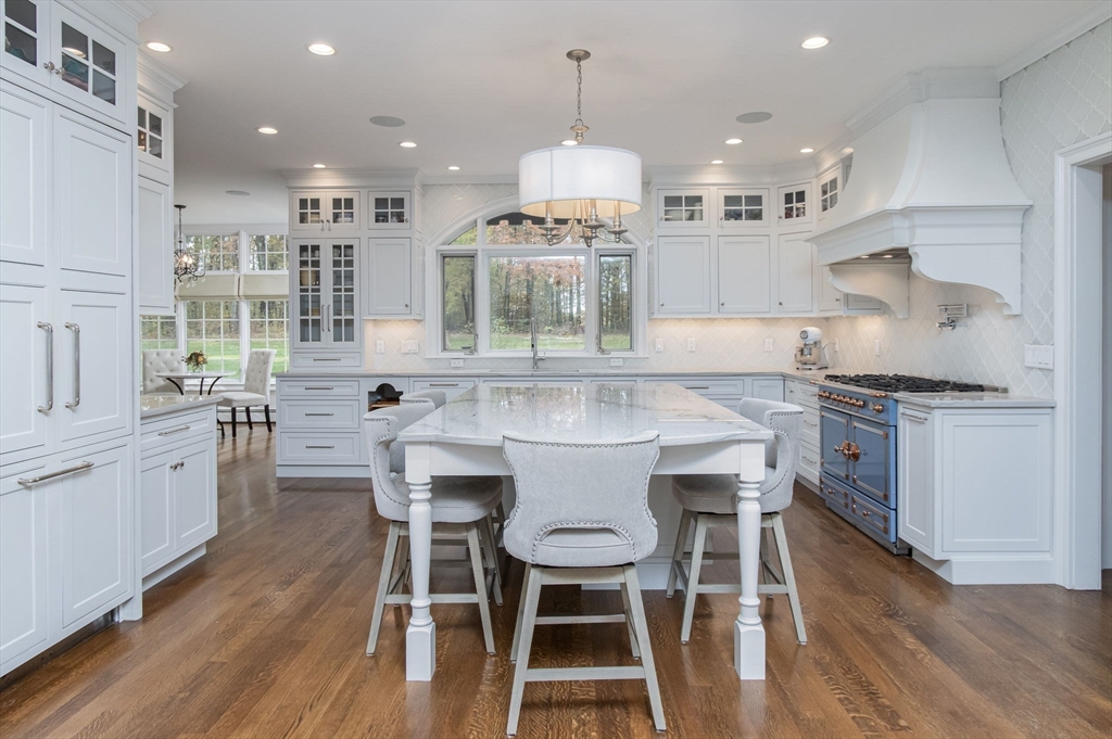 326 Old Ayer Road Groton, MA 01450 - Photo 7 of 42 a kitchen with stainless steel appliances a dining table chairs stove and cabinets