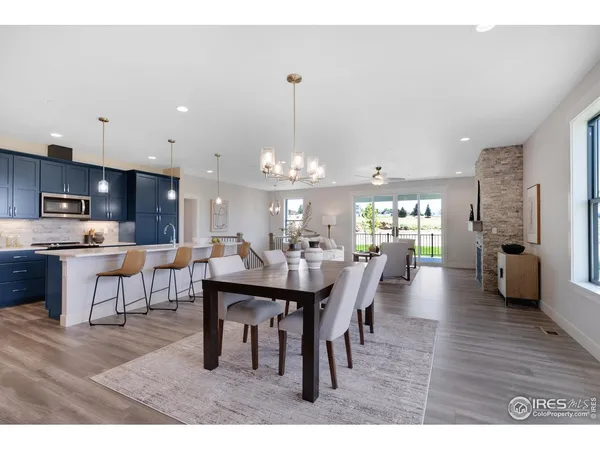 a dining room with furniture a chandelier and kitchen view