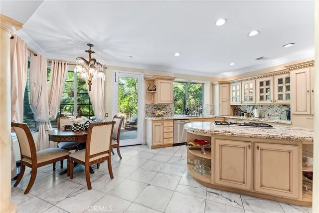 a kitchen with a stove a sink a dining table and chairs