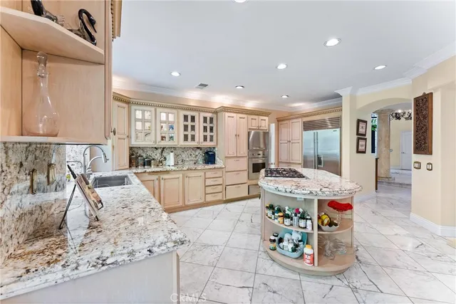 a kitchen with stainless steel appliances kitchen island granite countertop a sink and cabinets