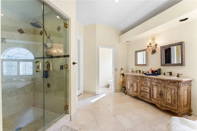 a spacious bathroom with a mirror a shower and a sink