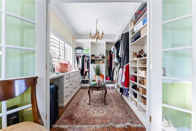 a view of walk in closet with clothes and shoes