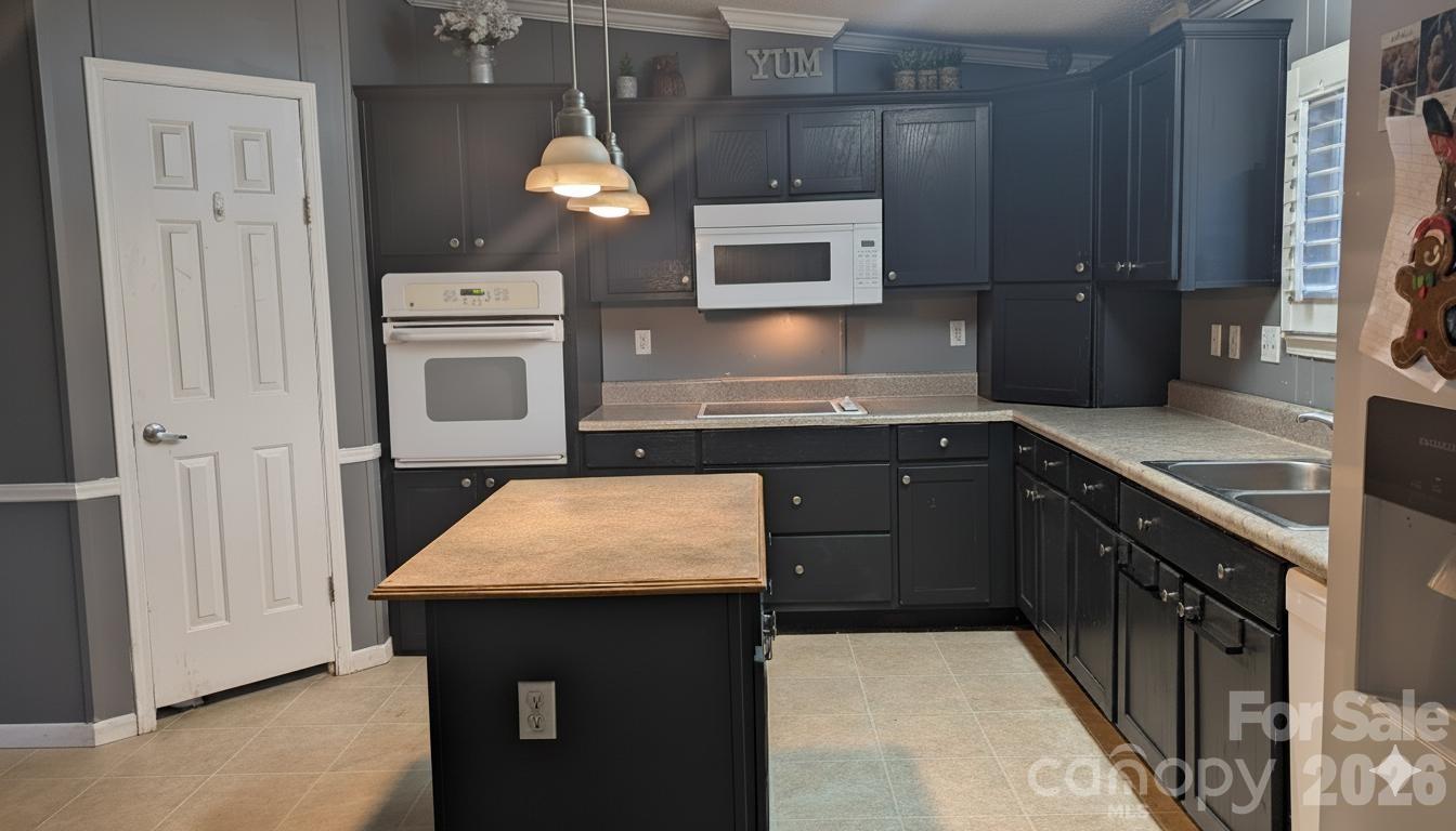 1163 Pit A Tat Road Kershaw, SC 29067 - Photo 4 of 13 a kitchen with stainless steel appliances granite countertop a sink and a stove top oven