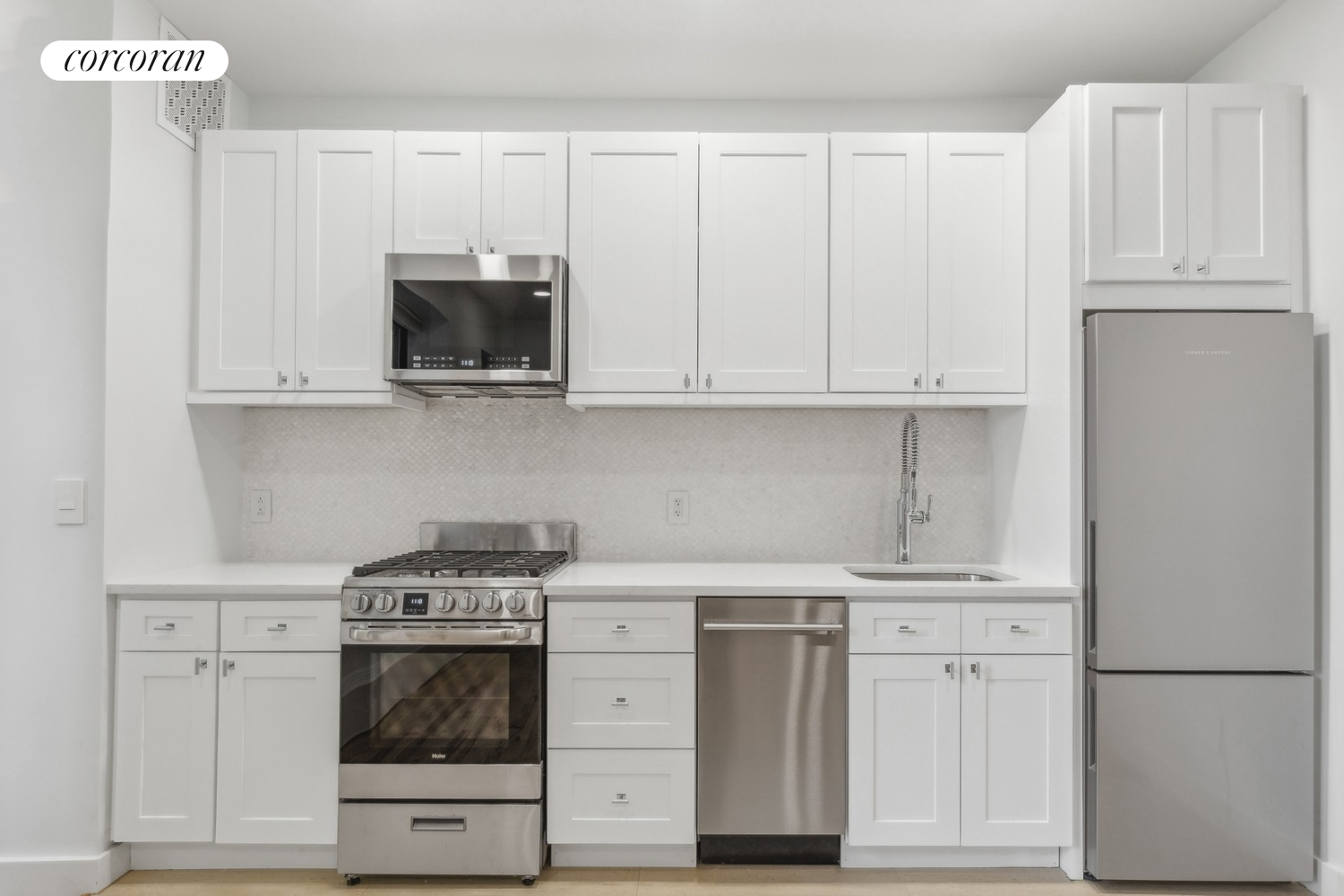 a kitchen with stainless steel appliances granite countertop white cabinets and a stove top oven
