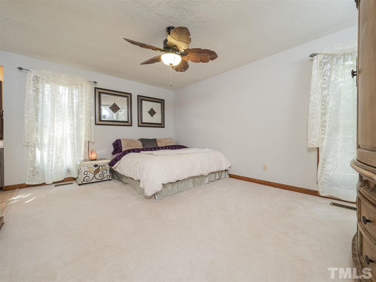 7220 Bluffside Court Raleigh, NC 27615 - Photo 11 of 23 a bedroom with a bed and a chandelier