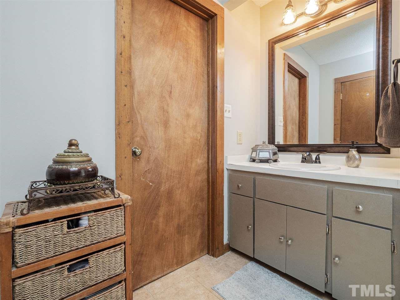 7220 Bluffside Court Raleigh, NC 27615 - Photo 12 of 23 a bathroom with a sink a vanity and a mirror