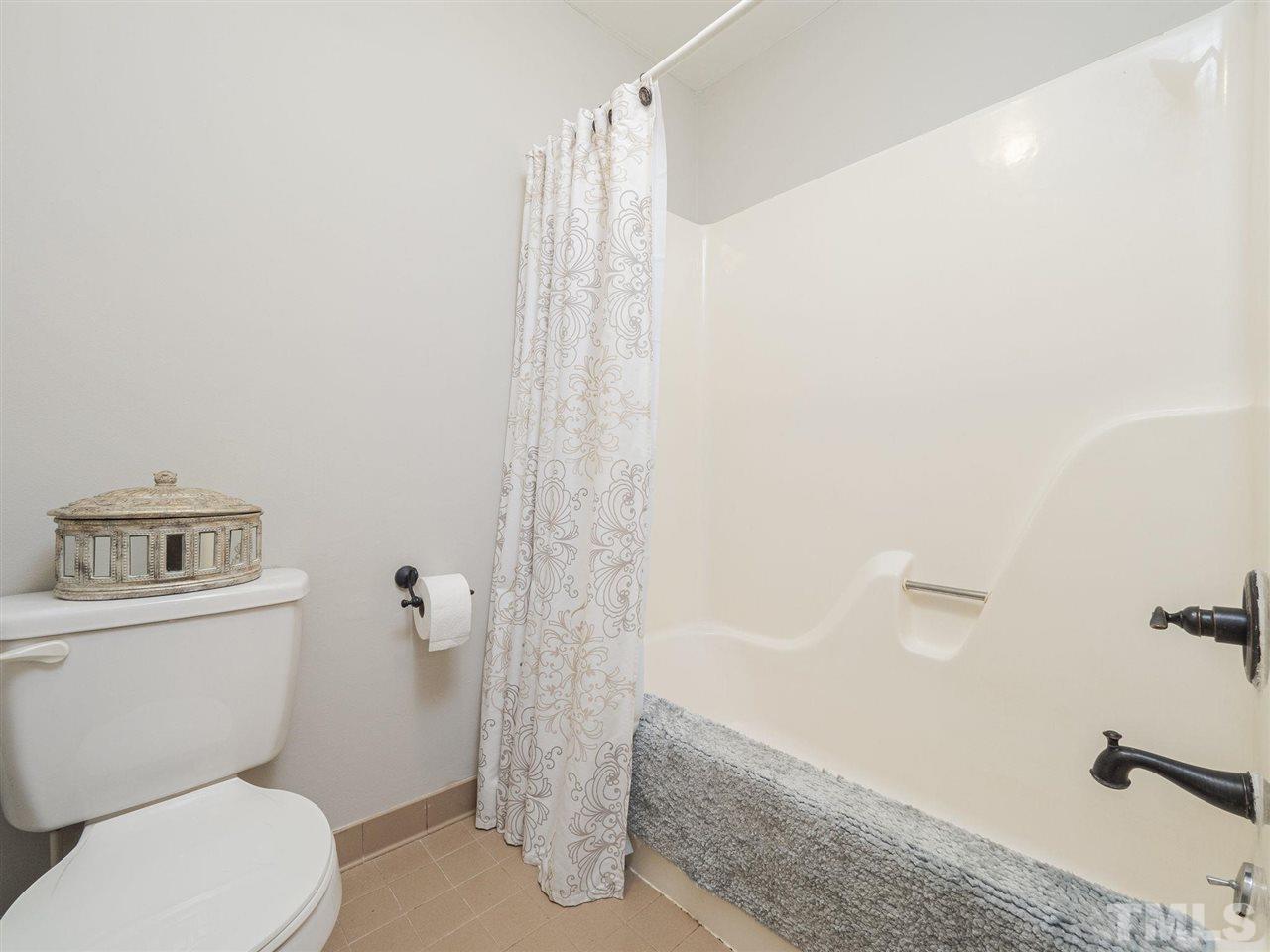 7220 Bluffside Court Raleigh, NC 27615 - Photo 13 of 23 a white toilet sitting next to a bath tub