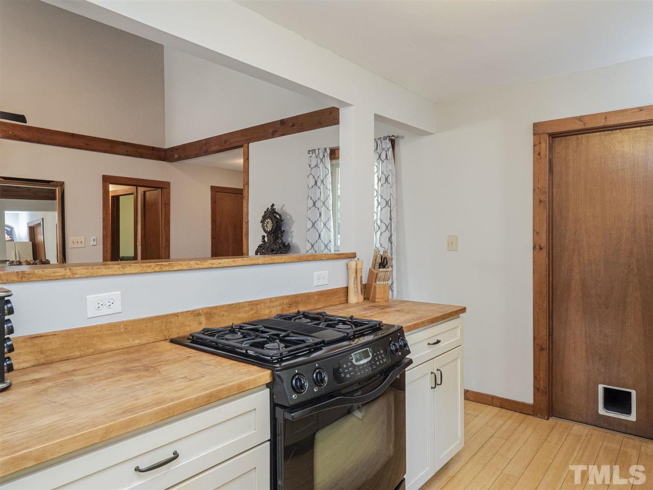 7220 Bluffside Court Raleigh, NC 27615 - Photo 9 of 23 a kitchen with a stove and a wooden floor