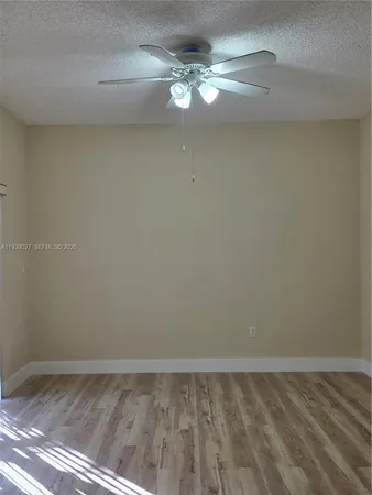 a view of a room with wooden floor and fan